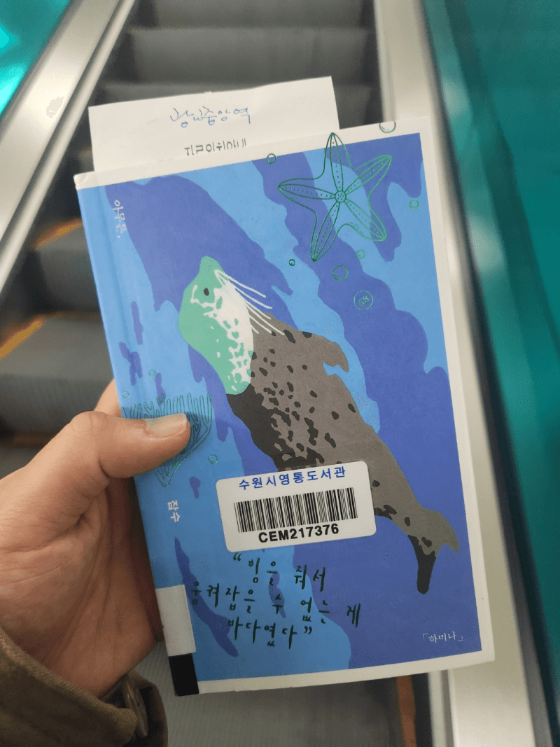 A blue map-patterned book cover held up on an escalator